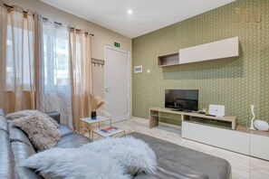 Un saló modern amb un sofà, una televisió i una taula petita.