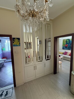A room with a white wardrobe, a chandelier, and a painting on the wall. - Elegant City Center Apt. in Durrës - Modern Comfort, Near Beach &Attractions (Durrës)