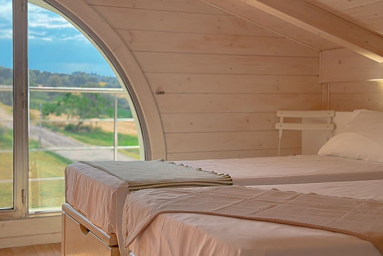 Una baita con un'ampia finestra, un letto a castello e interni in legno.