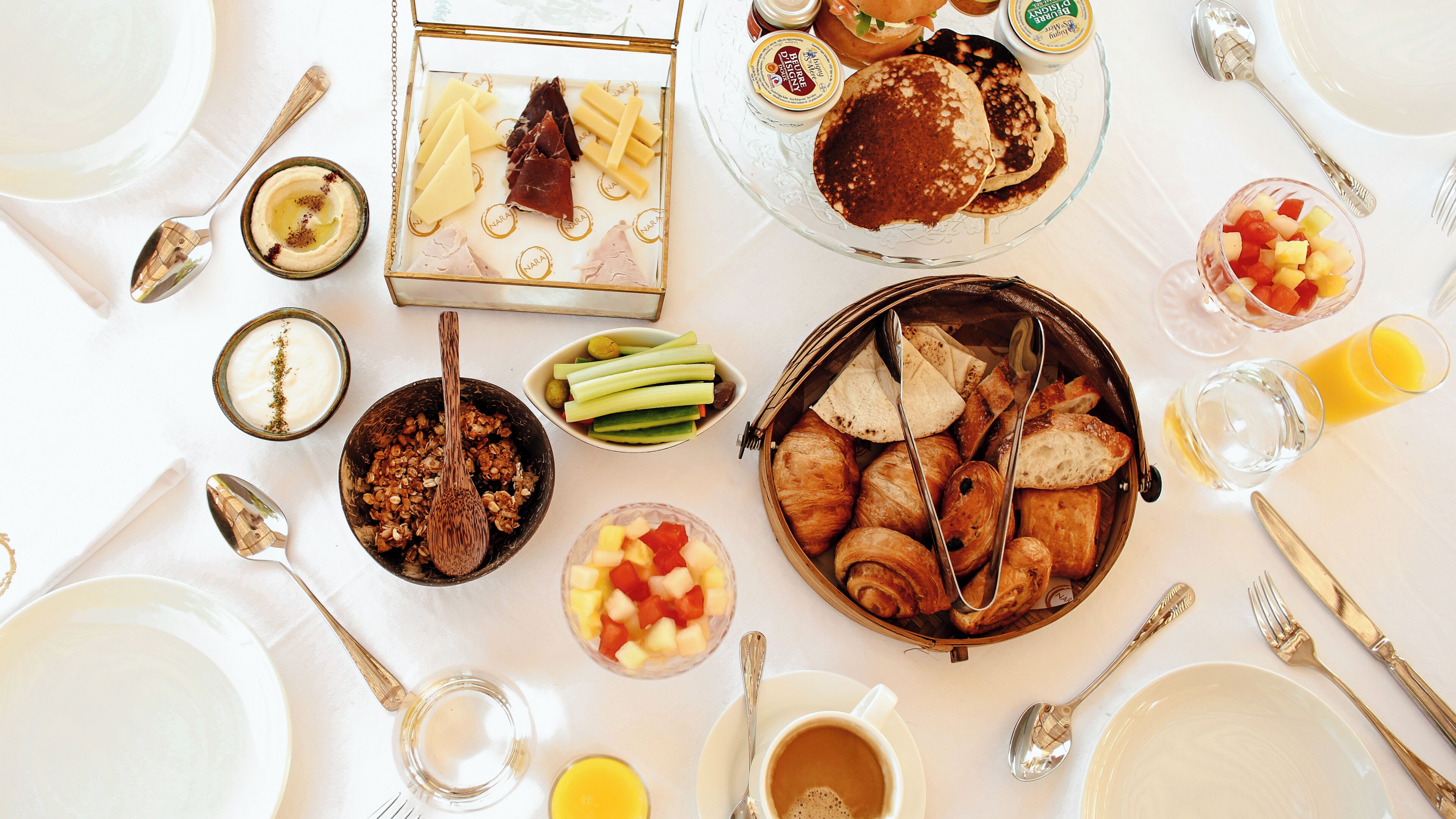 A breakfast setting with various food items and utensils.
