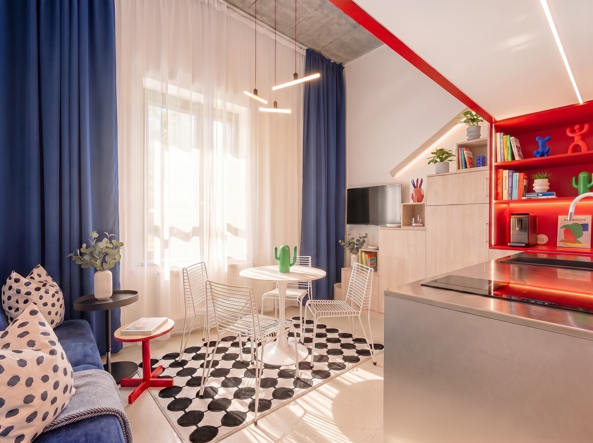 A modern living room with a sofa, coffee table, and chairs, a kitchen area with a red shelf, and a black and white checkered floor.