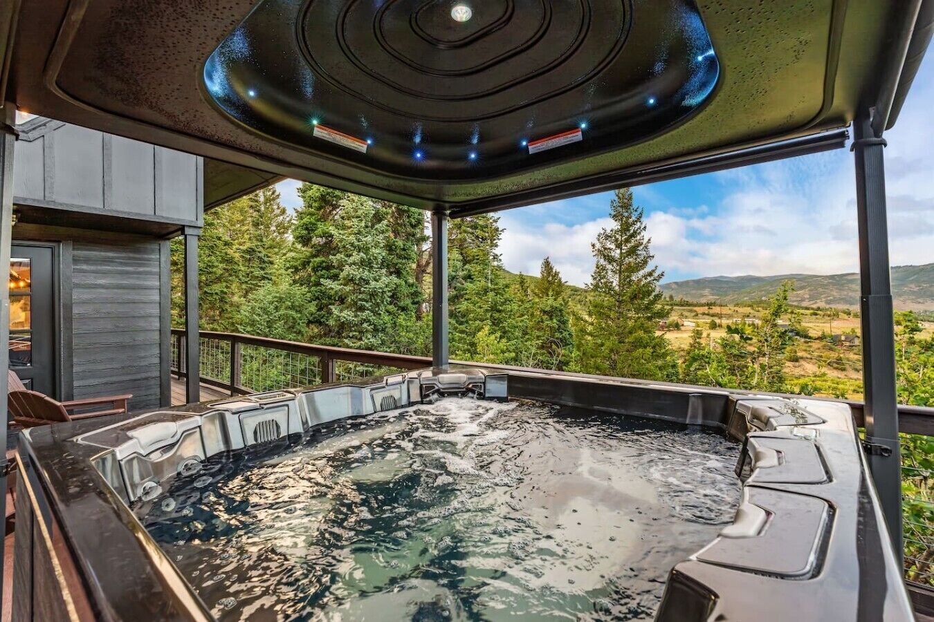 Ein Whirlpool mit Blick auf einen Wald und Berge.