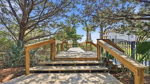 A wooden staircase leading up to a building, surrounded by trees and greenery. - Steps from the ocean in Debordieu (Georgetown)