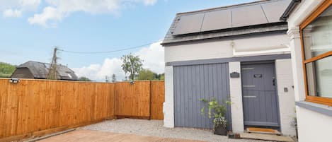 Una propiedad residencial con garaje, cerca de madera y entrada pavimentada.