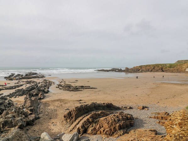 A beach with rocky formations and a sandy shore. - Coach House (Beaworthy)