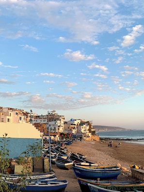 Un pueblo costero con edificios, barcos y una playa.