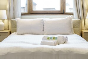 A neatly made bed with white linens, a window with curtains, and a bedside lamp. - Beautiful 4BR Home in Peaceful Area | Lots Around - Pass the Keys (Belfast)