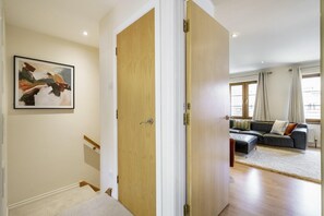 A hallway leading to a living room with a sofa and a painting on the wall. - Beautiful 4BR Home in Peaceful Area | Lots Around - Pass the Keys (Belfast)