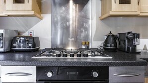 Eine Küche mit einem Edelstahlherd, einer Kaffeemaschine und einem Toaster.