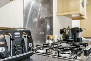 A kitchen with a gas stove, a coffee maker, and a toaster. - Beautiful 4BR Home in Peaceful Area | Lots Around - Pass the Keys (Belfast)