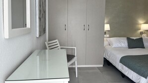 A hotel room with a bed, a chair, a table, and a wardrobe. - Beachfront Escape in Miraflores - Pass the Keys (Las Lagunas de Mijas)