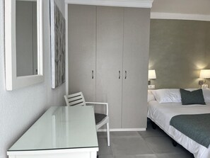 Ein Hotelzimmer mit Bett, Stuhl, Tisch und Schrank.