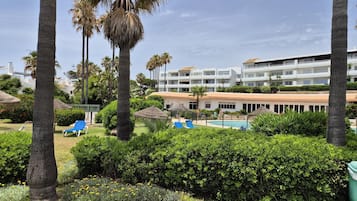 Ein Resort mit Schwimmbad, Liegestühlen und Palmen.