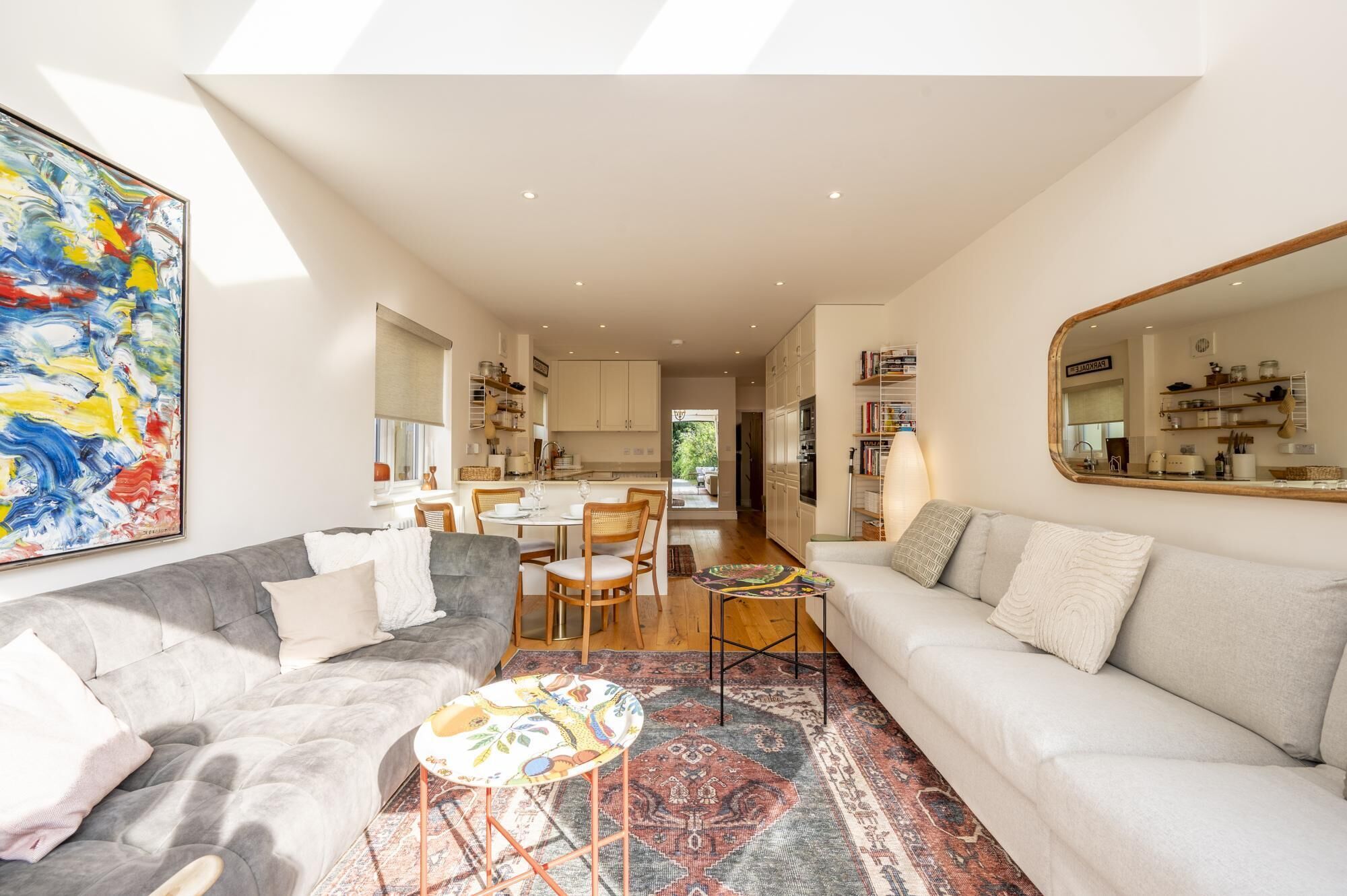 Un salon moderne comprenant un canapé, une table basse et un coin repas avec des chaises et une table.