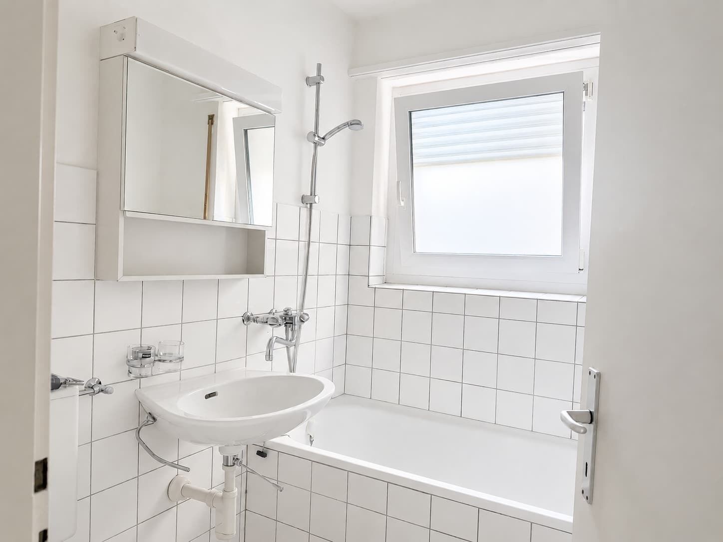 Ein Badezimmer mit Waschbecken, Spiegel und Dusche.