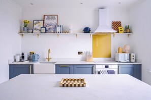 Una cucina moderna con un piano di lavoro in marmo, una scacchiera e diversi elettrodomestici.