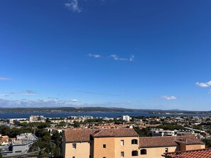 Eine Küstenstadtlandschaft mit Gebäuden, blauem Himmel und weiter Wasserfläche im Hintergrund.