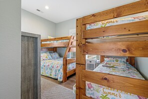 A room with two bunk beds, each with a wooden frame and a beach-themed bedspread. - Steps to Sand-Full Remodel Like New! (Corolla)