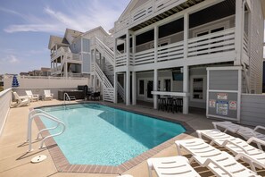 A swimming pool with a white pool ladder, lounge chairs, and a lifeguard stand. - Steps to Sand-Full Remodel Like New! (Corolla)