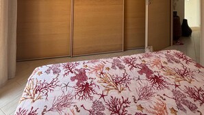 A bedroom with a bed, a wardrobe, and a door leading to another room. - Villa Faro Sea (San vito lo capo)