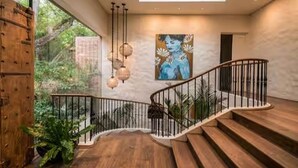 Eine moderne Treppe mit Glasdach, Holzstufen und Metallgeländer.