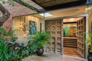A modern building with a wooden staircase, a large potted plant, and hanging light fixtures. - Spacious spectacular 9-bedroom Fresnaye Villa (Cape Town)
