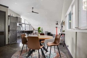 A modern kitchen with a dining area, featuring a round table, chairs, and a ceiling fan. - Mid-Century Mountain View Getaway for 4 (Billings)