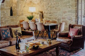 Ein gemütliches Wohnzimmer mit Ledersofas, einem Holztisch und einer Steinwand.
