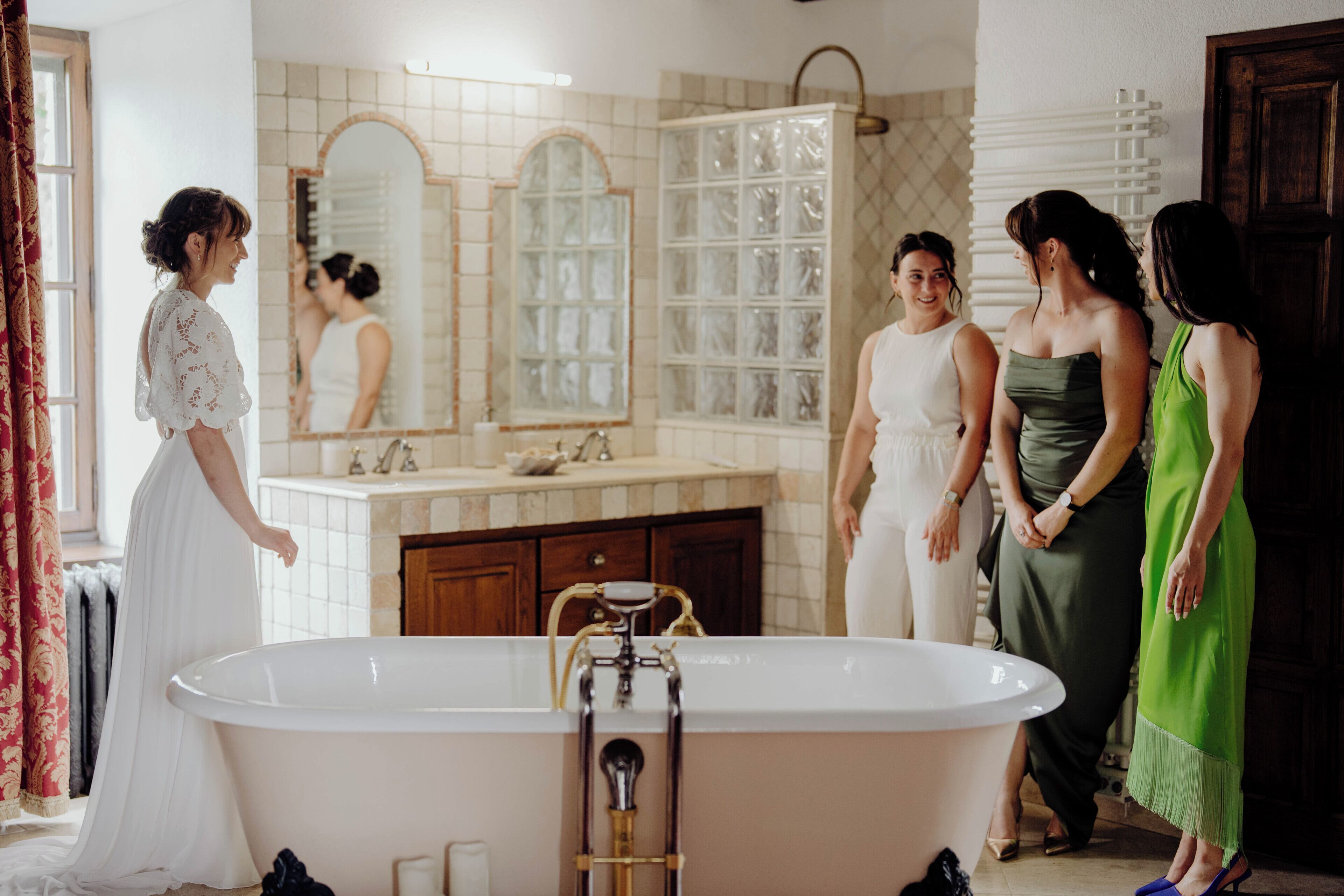 Une salle de bain avec une baignoire sur pieds, un grand miroir et un meuble-lavabo avec un pare-éclaboussures carrelé.