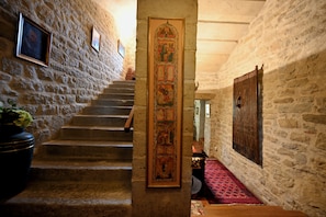A stone staircase leading to a higher level, a wooden door with a decorative panel, and a patterned carpet. - Château de Tournou – Sleeps 15, 7 Bedrooms & Private Infinity Pool (Castelreng)
