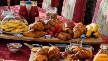 Un buffet de petit-déjeuner comprenant des viennoiseries, des fruits et diverses garnitures.