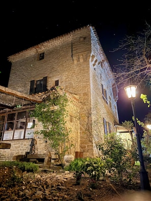 Un bâtiment en pierre doté d’un balcon et d’un lampadaire.