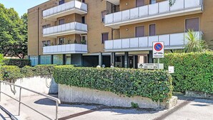 Un immeuble à plusieurs étages doté de balcons, d’un panneau indiquant qu’il est interdit de se garer et d’un autre panneau indiquant le numéro de l’unité de copropriété, soit le 23.