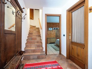 Eine Holztreppe führt zu einem Schlafzimmer mit einem Bett und einem Schrank aus Holz.