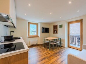 Una cocina moderna con comedor, televisor y vistas al exterior.