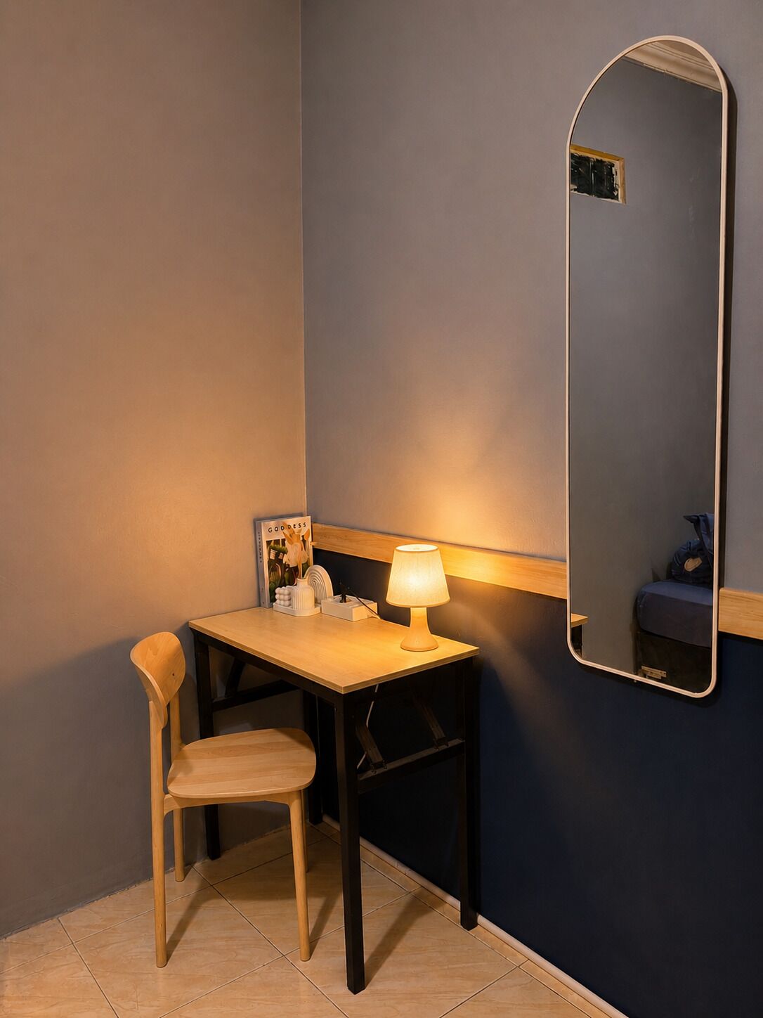 A small room with a desk, chair, and a mirror.