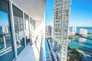 A high-rise building with large windows, a balcony, and a view of a marina and other buildings. - Icon brickell | luxury highrise 31st floor (Miami)