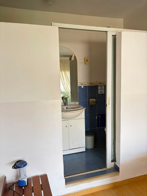 Une salle de bain comprenant un lavabo, des toilettes et un espace douche.