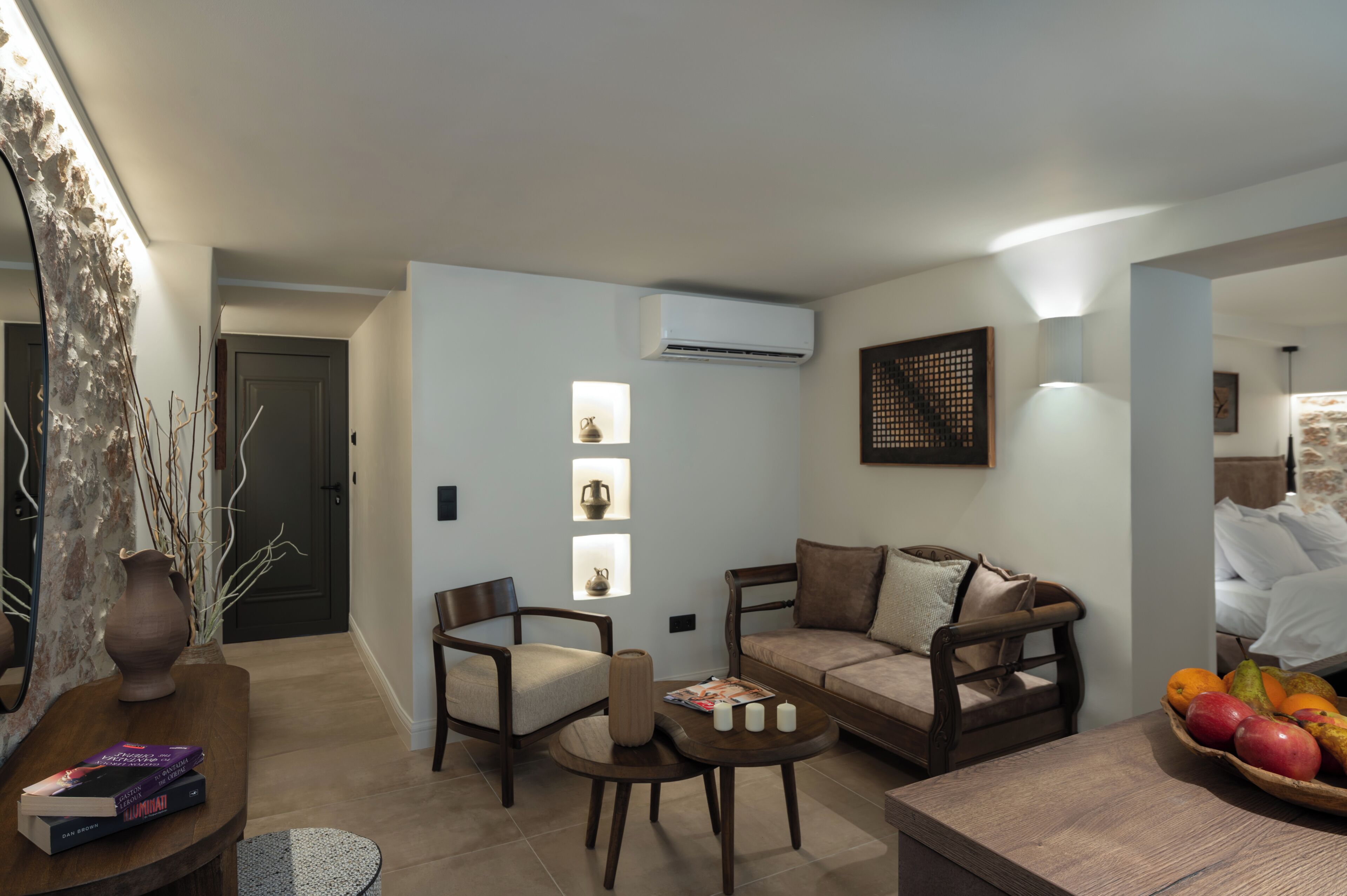 A modern living room with a sofa, chairs, a coffee table, and a fruit basket.