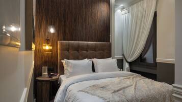 Une chambre avec un grand lit, un mur d’accent en bois et une table de chevet avec une lampe.