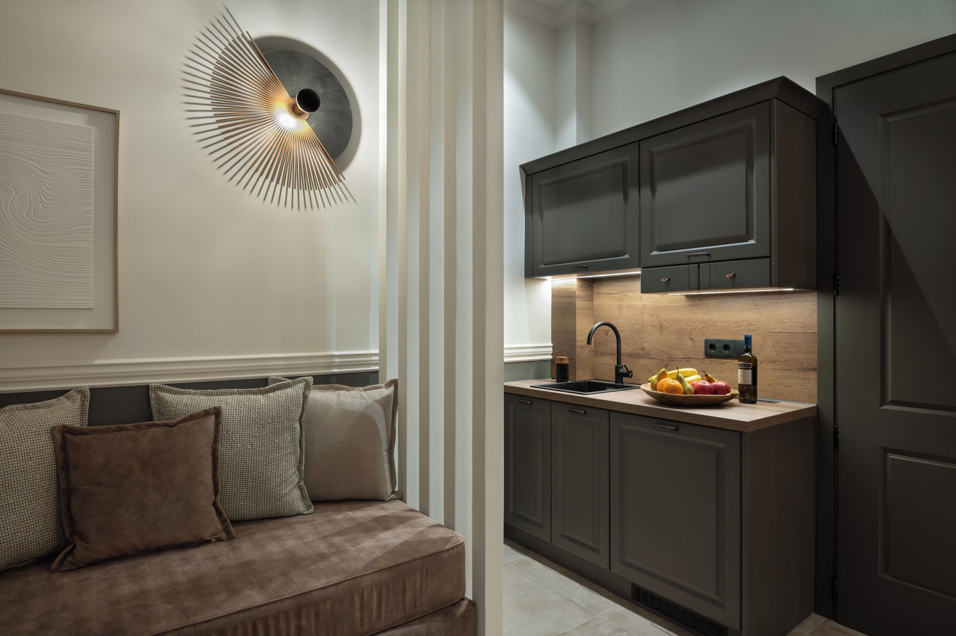 Une cuisine moderne avec des meubles de couleur sombre, un plan de travail en bois et un évier encastré.