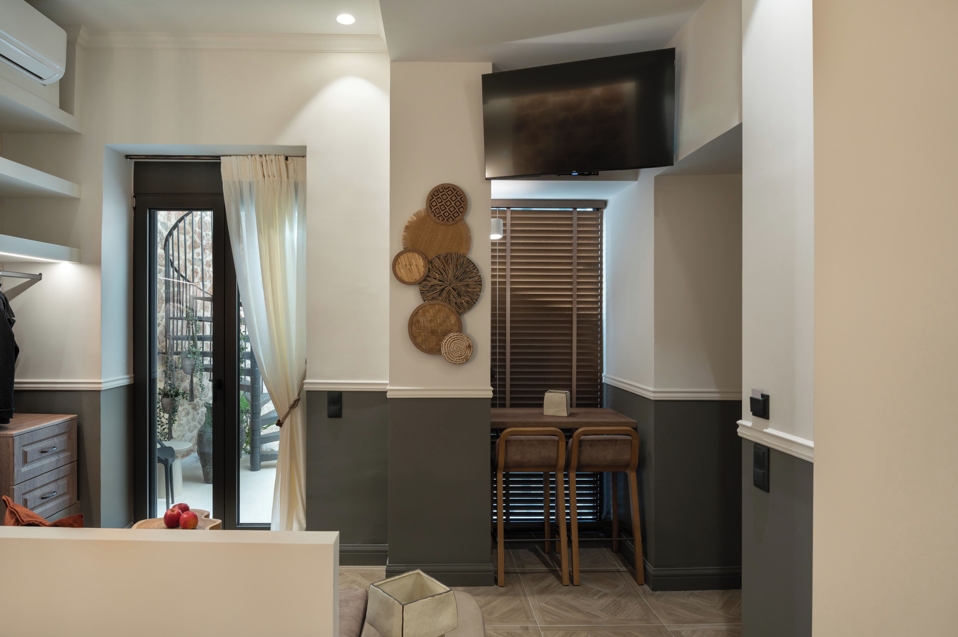 Una cucina moderna con zona pranzo, condizionatore d'aria integrato e TV a parete.