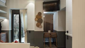 Una cocina moderna con comedor, aire acondicionado integrado y televisor montado en la pared.