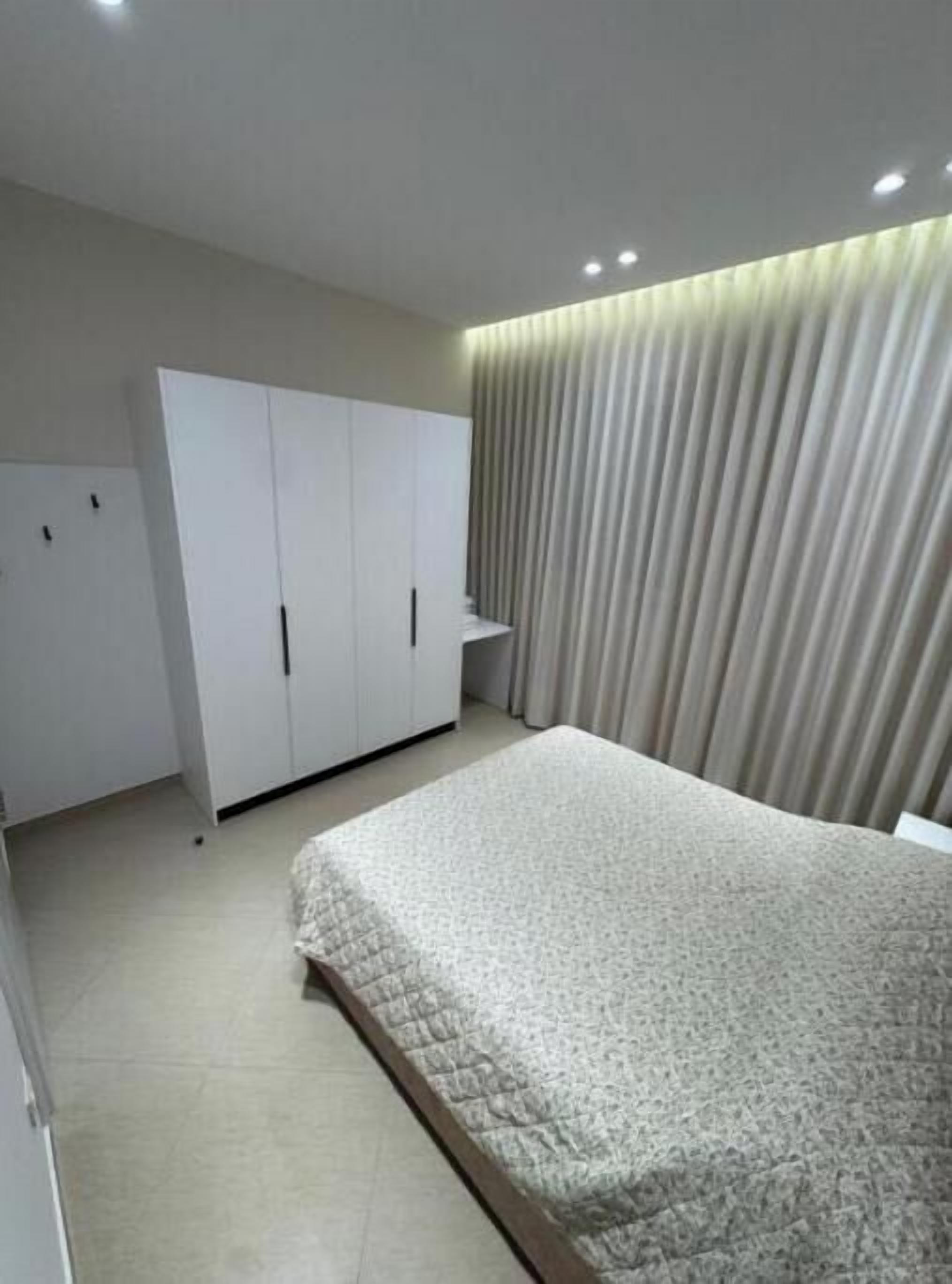 A bedroom with a bed, a wardrobe, and a curtain.