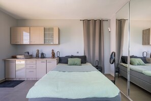 Un dormitorio con cama, mesita de noche, espejo y armario.