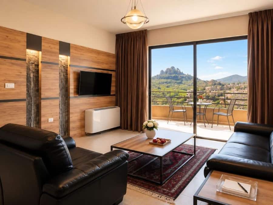 Ein modernes Wohnzimmer mit einer Couch, einem Couchtisch und einem an der Wand befestigten Fernseher.