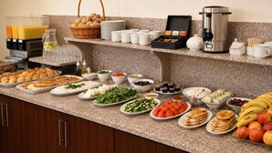 A buffet with various food items, a coffee maker, and a juice dispenser. - Iris Flower (Jezzine)