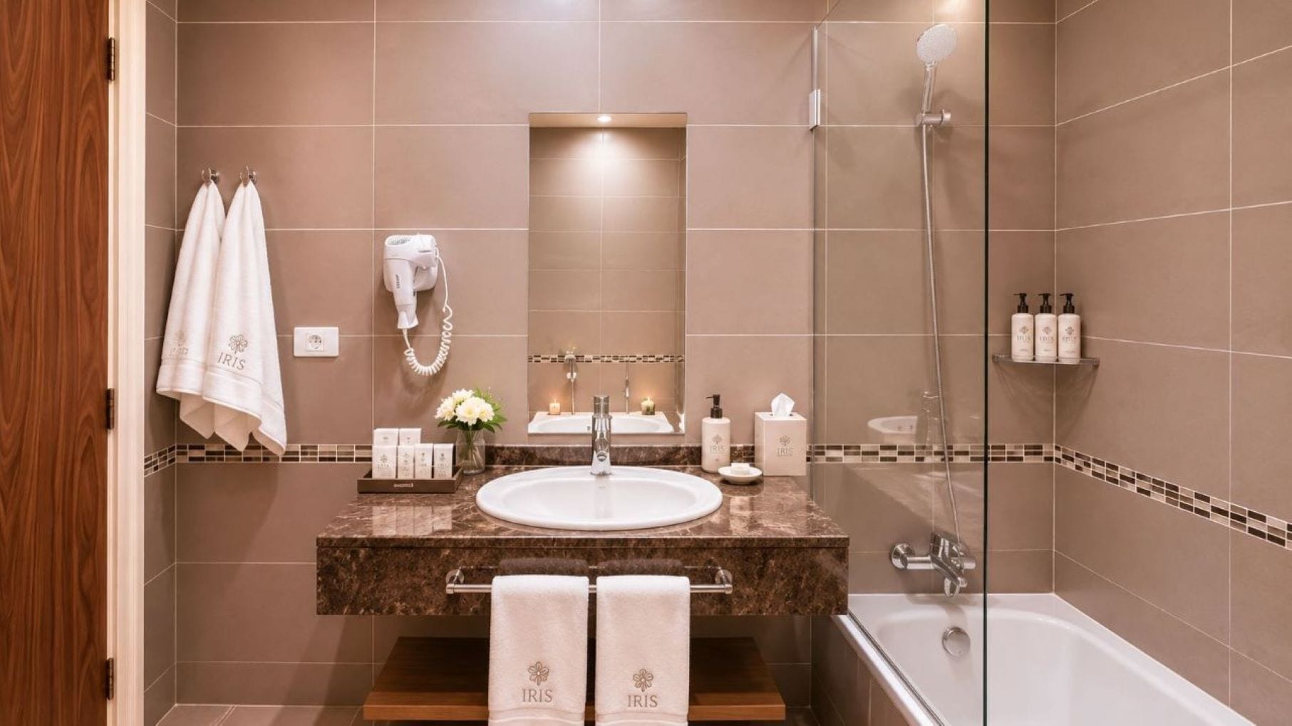 Casa de banho com lavatório, espelho, porta-toalhas, secador de cabelo e chuveiro.