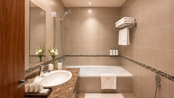 A modern bathroom with a bathtub, a sink, and a mirror.