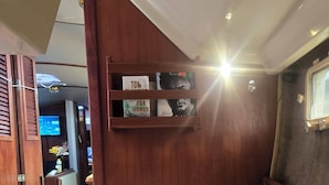 Una camera da letto con un letto, uno scaffale in legno con dei libri e una finestra.
